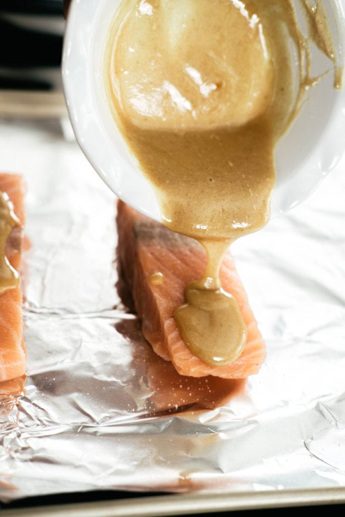 pouring honey mustard over salmon