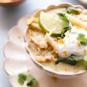 close up photo of white chicken chili garnished with lime