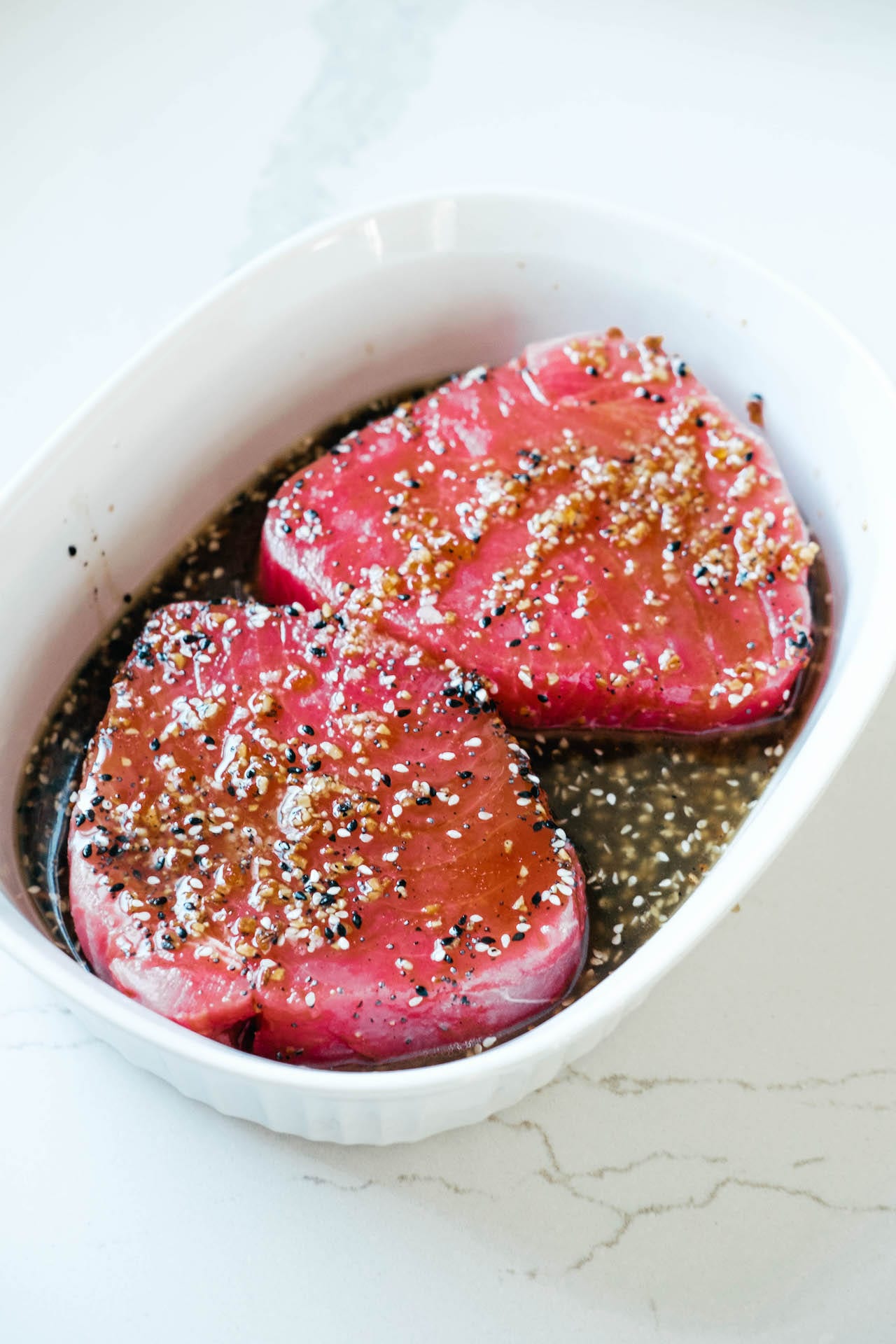 Raw Ahi Tuna marinating in a shallow dish. 