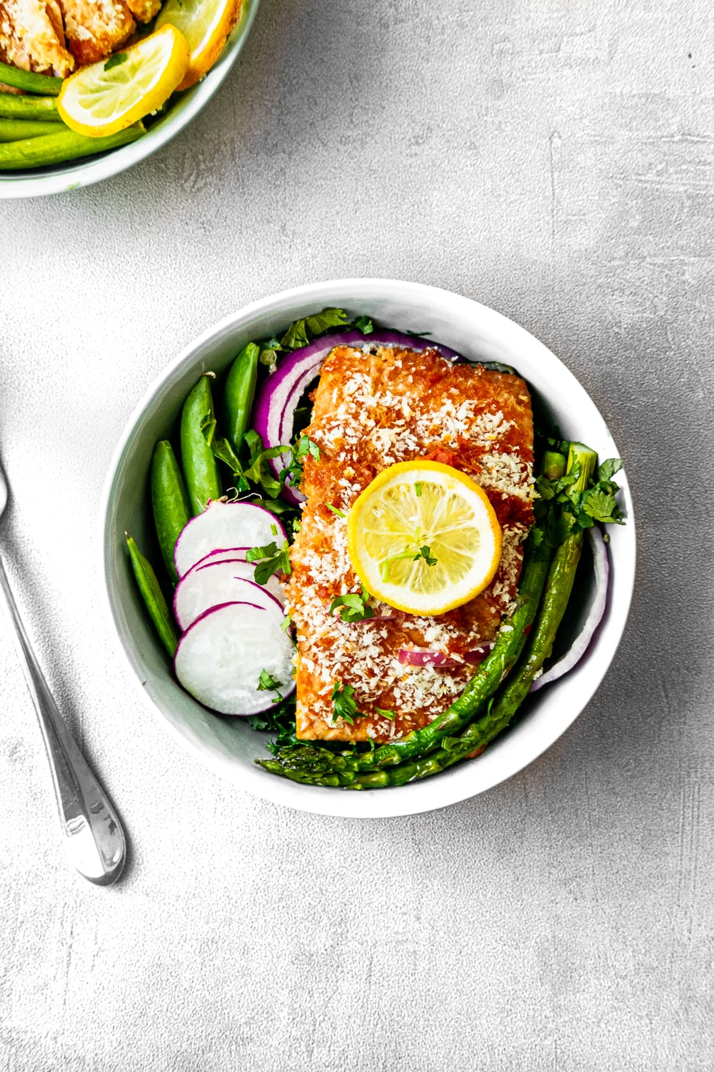 Bowl of crunchy Thai salmon with asparagus, radish, and peas. 
