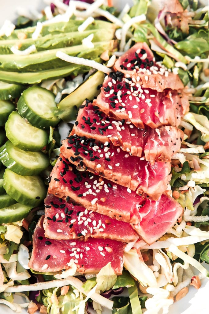 close up of ahi tuna with sesame seeds on salad
