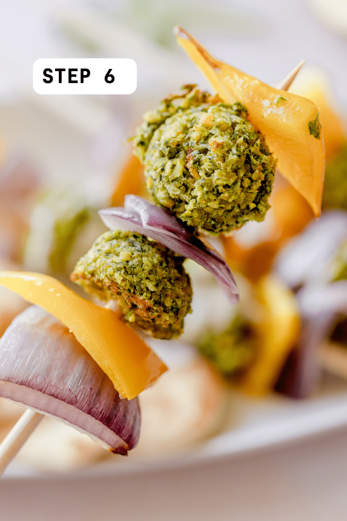 Skewer of cooked falafel, peppers, and onion. 