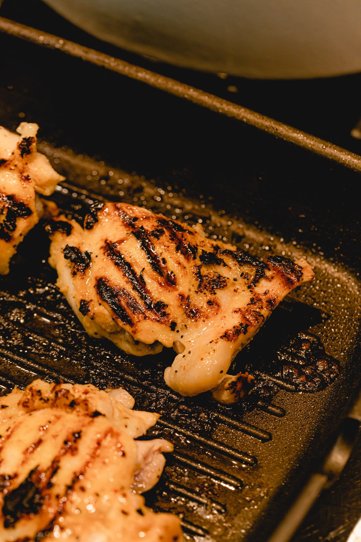 Grilling chicken thighs on a grill pan. 