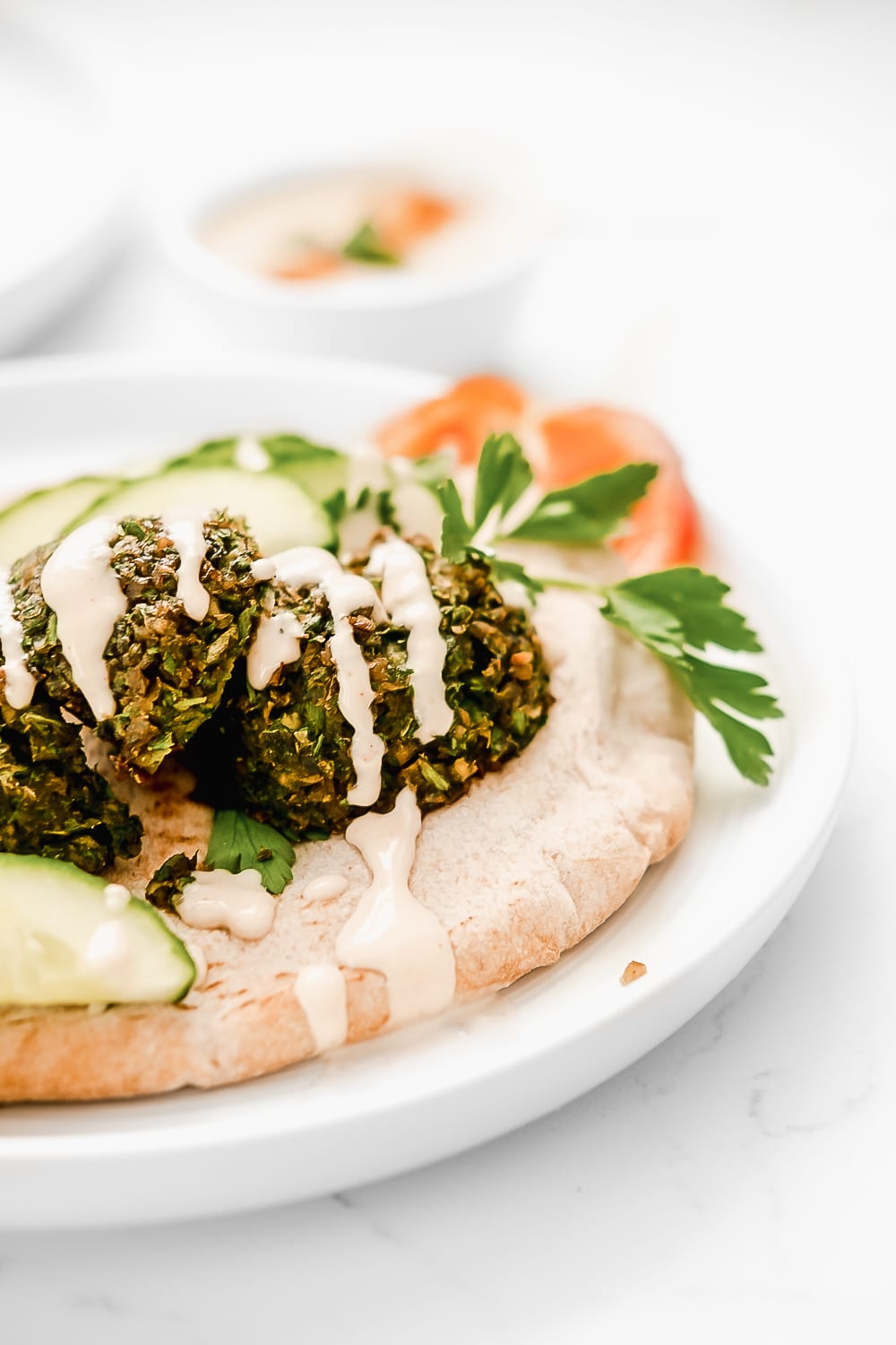 Baked falafel on pita drizzled with tahini sauce