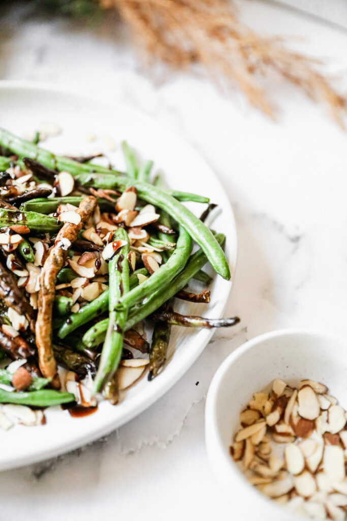 close up of air fried green beans with almond garnish