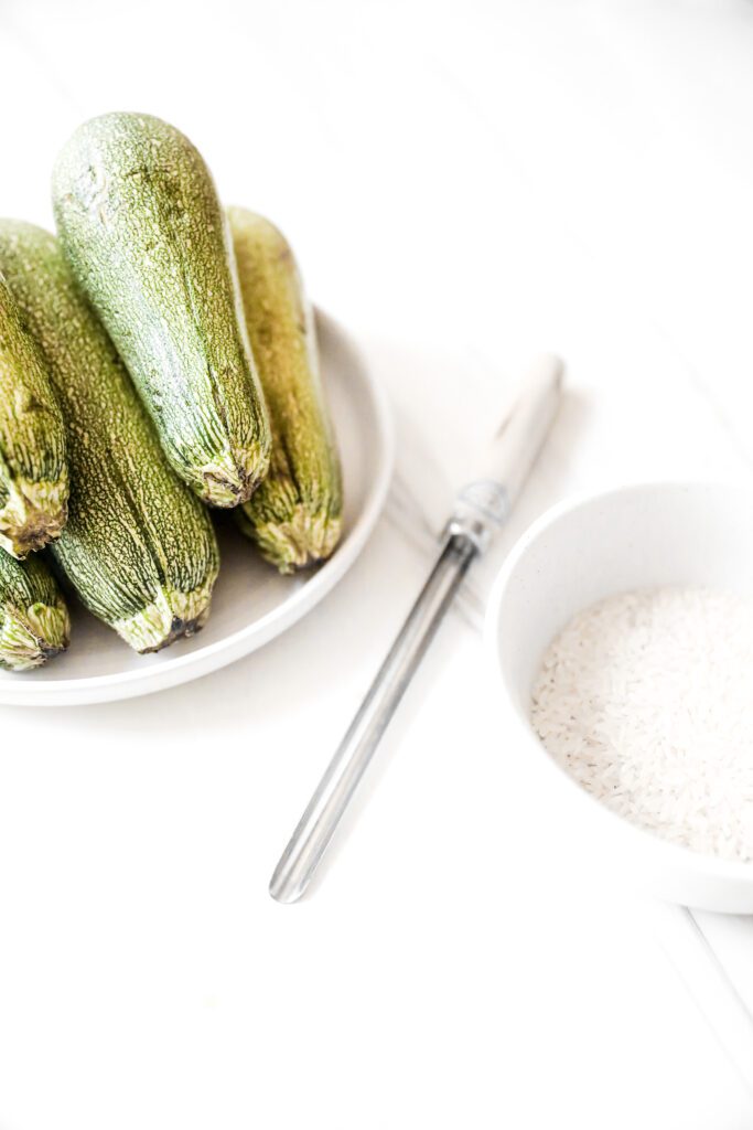 Lebanese zucchini on a white plate next to a zucchini corer