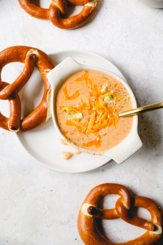 bowl of beer cheese soup surrounded by soft pretzels