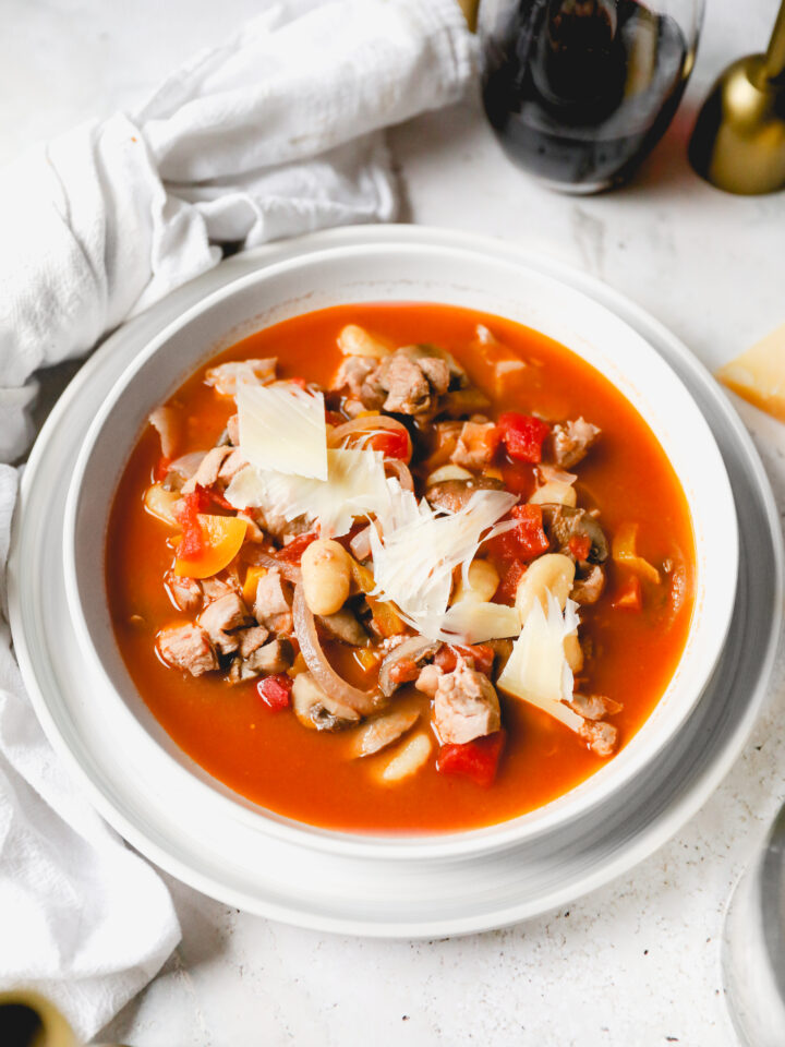 bowl of chicken cacciatore soup topped with parmesan