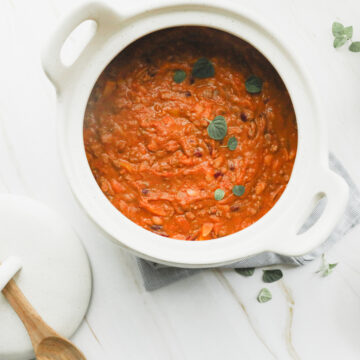 pot of creamy pumpkin chili with lid and white linen