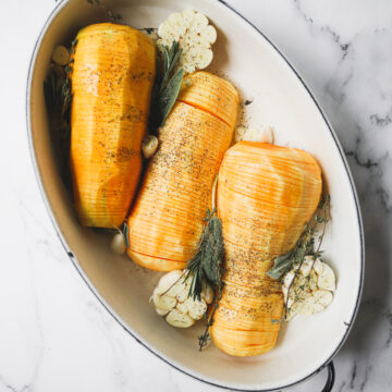 hassle back butternut squash in a roasting pan