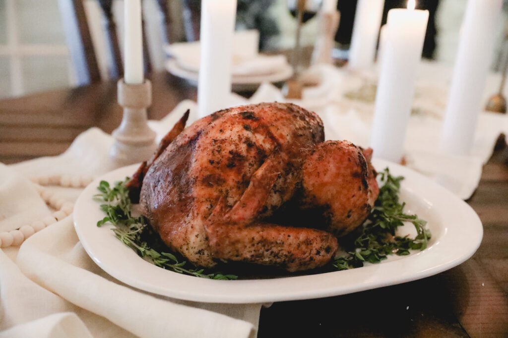 thanksgiving turkey on a set table with white linen 