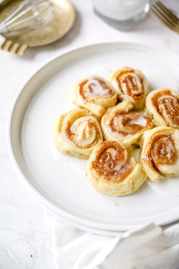 air fried cinnamon rolls on a white plate with icing 