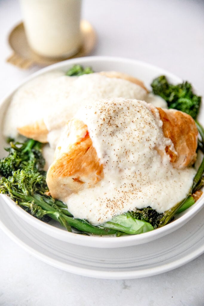 creamy cauliflower Alfredo sauce poured over chicken and broccoli 