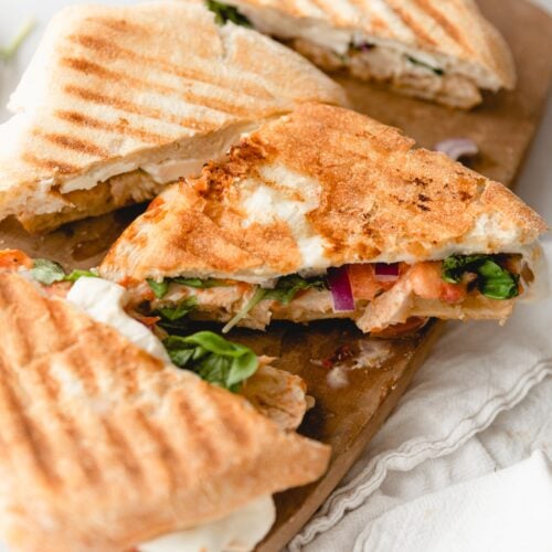 frontega chicken panini sandwich halves on cutting board