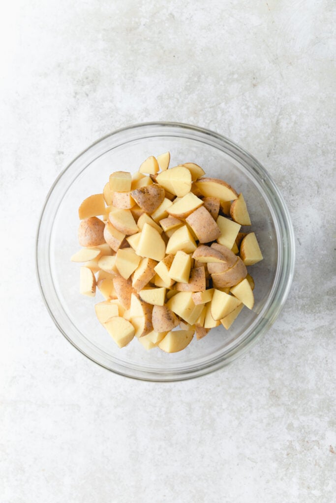 chopped russet potatoes in a glass bowl 
