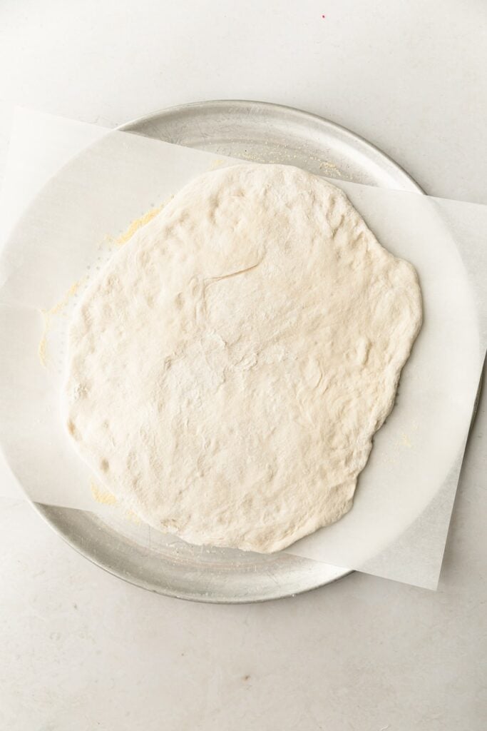 pizza dough rolled out into a circle