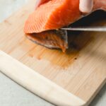 removing salmon skin with a knife