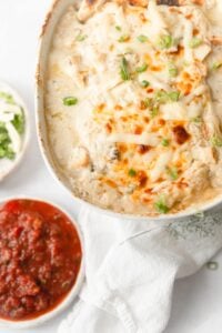 white chicken enchilada in baking dish with salsa on the side