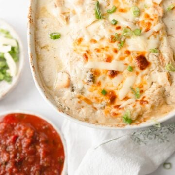 white chicken enchilada in baking dish with salsa on the side
