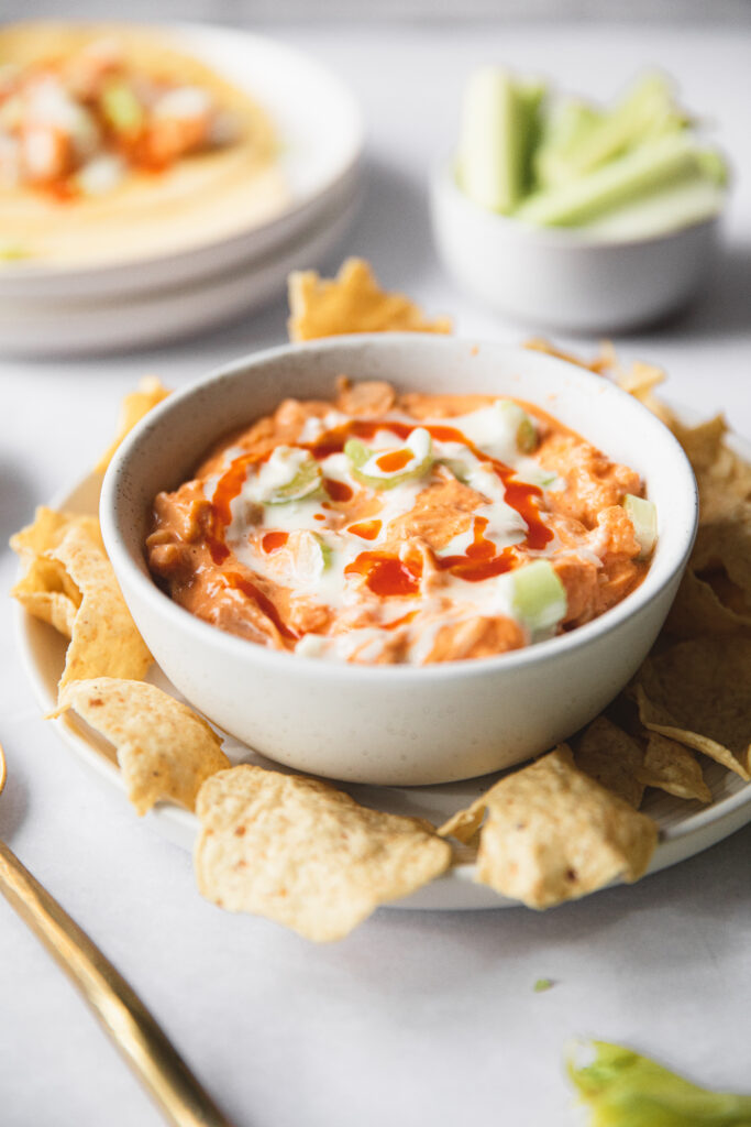 white bowl of buffalo dip with tortilla chips 