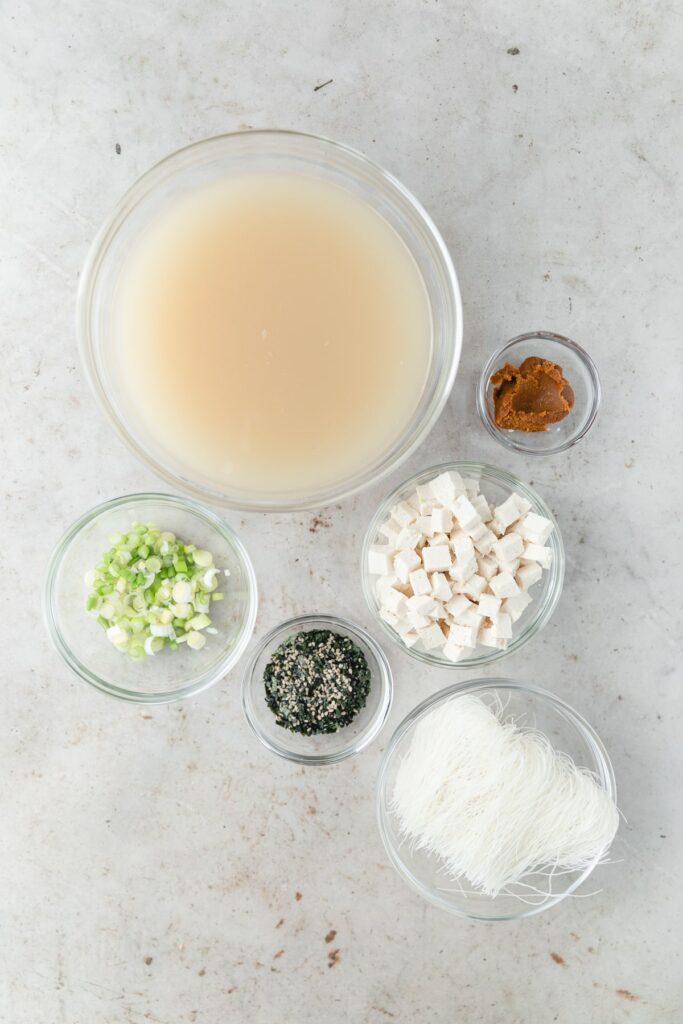 all ingredients for miso soup in clear glass bowls