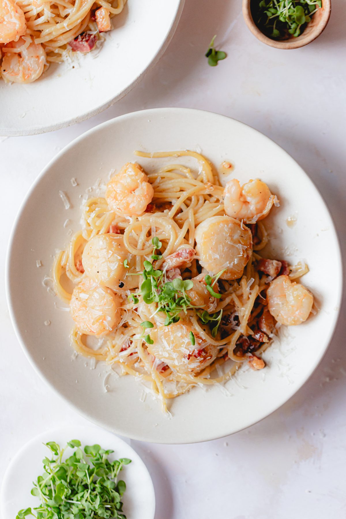 Final plated shrimp scallop pasta garnished with micro greens. 