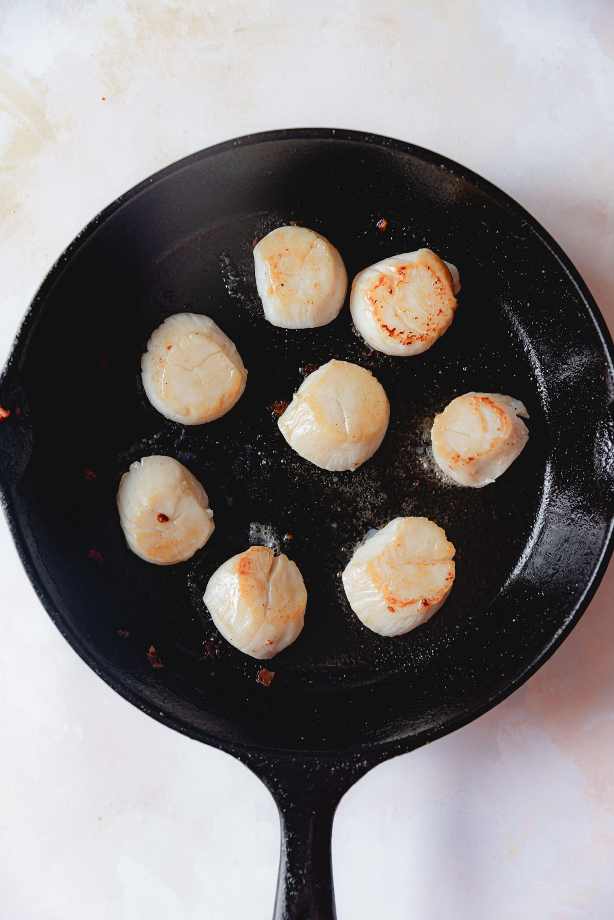 Seared scallops on a cast iron skillet. 