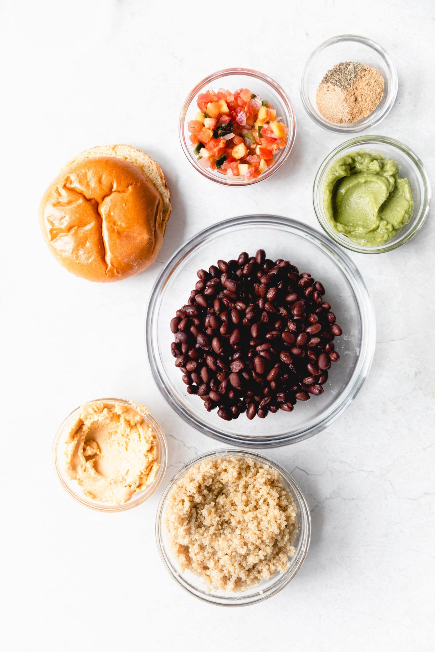 black bean nacho burger ingredients in clear glass bowls