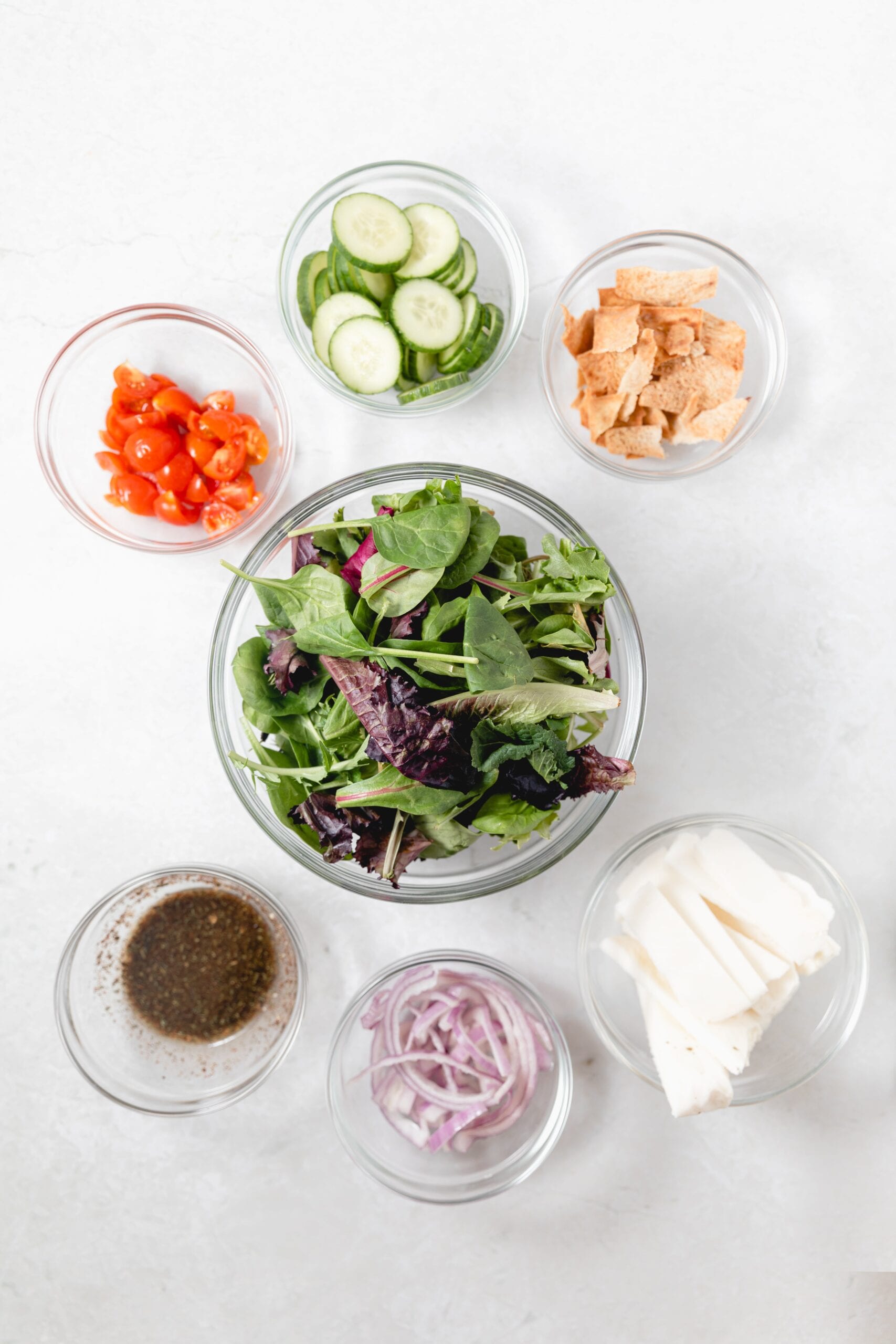 Ingredients for halloumi salad in glass bowls
