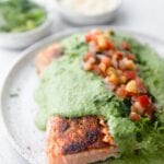 plate of salmon covered in creamy poblano sauce and topped with pico