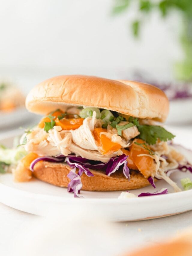 A close-up shot of the crockpot Hawaiian chicken in a sandwich.