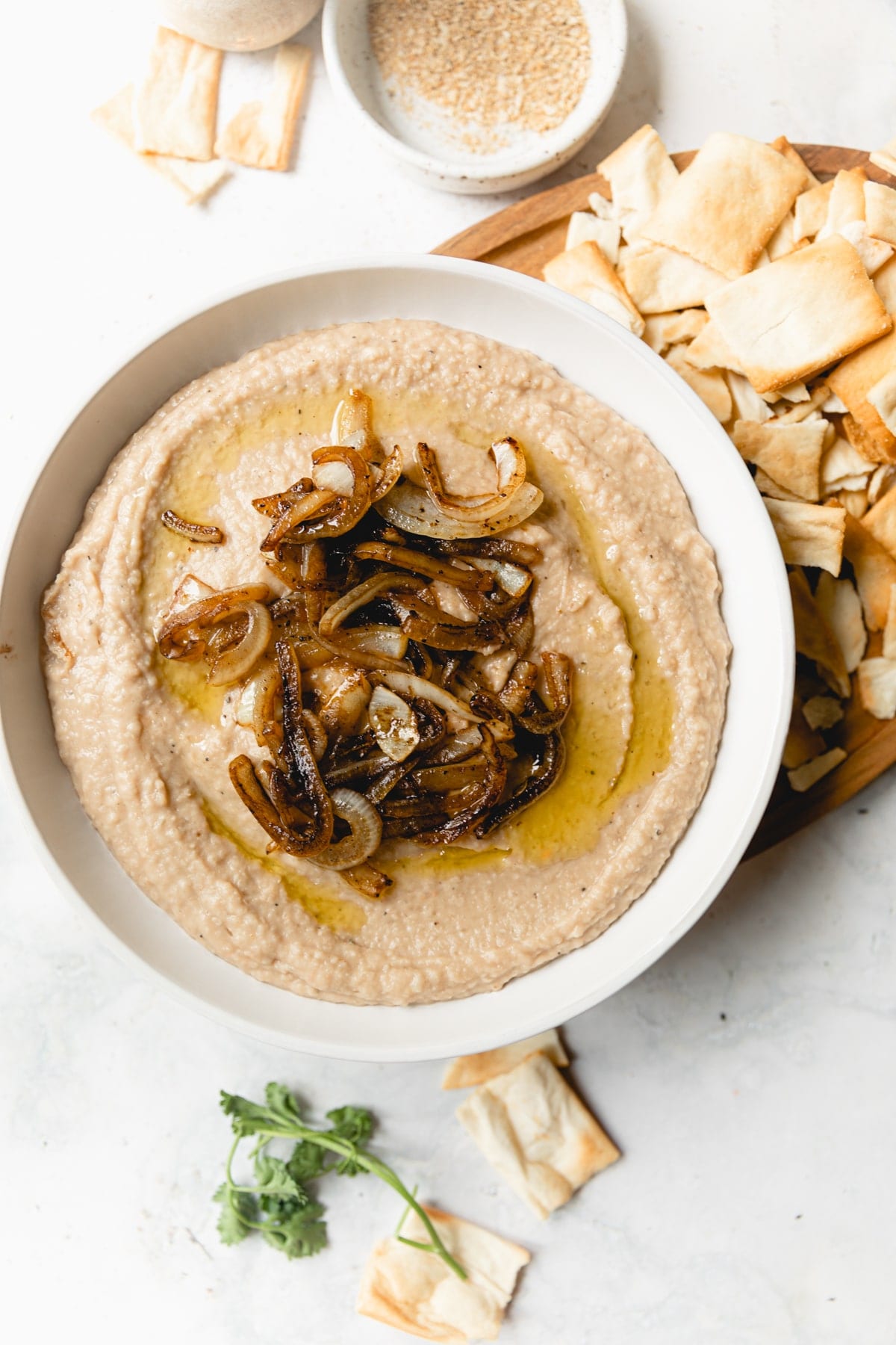 white bean dip topped with caramelized onions served with pita chips