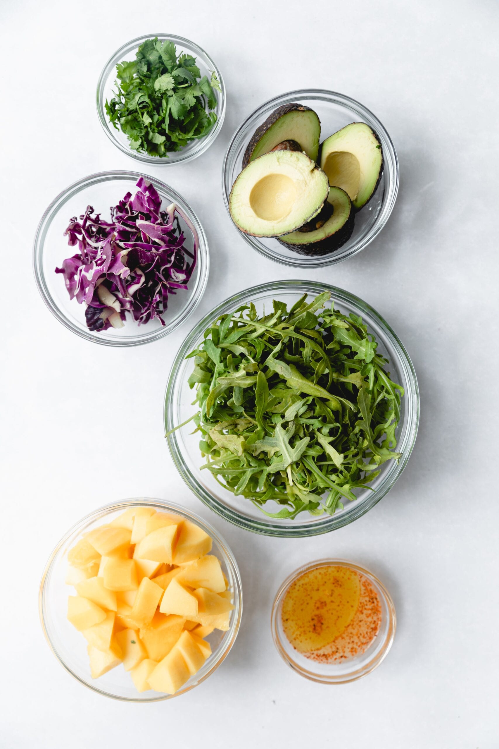 Clear glass bowls with Mango salad ingredients 
