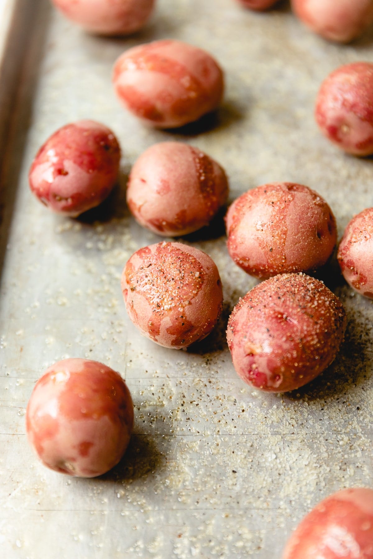 olive oil covered red potatoes on a sheet tray