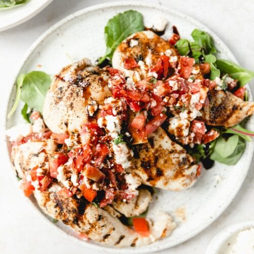 grilled chicken topped with tomato, feta, and basil salad