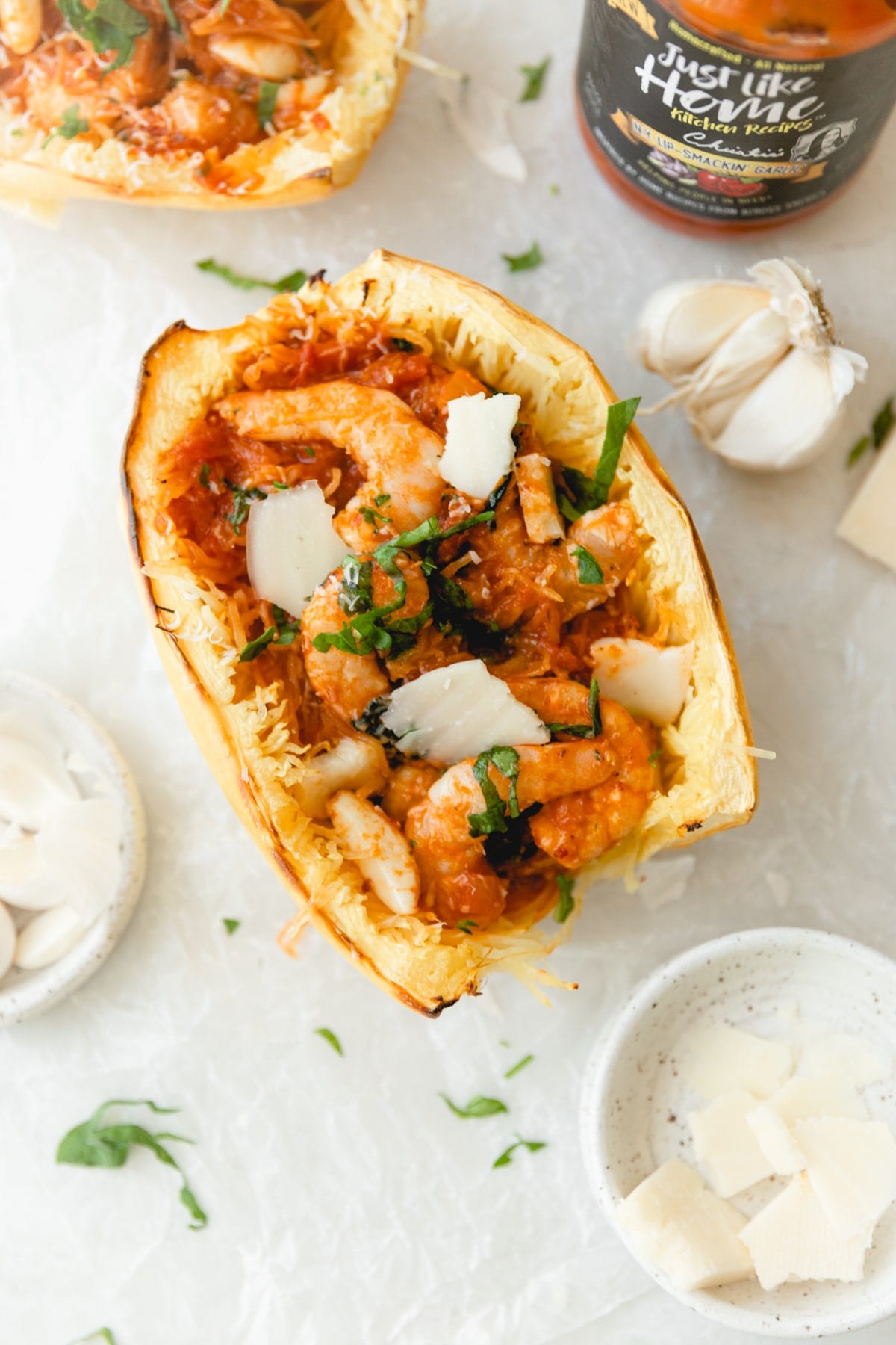 garlic marinara shrimp and spaghetti squash on parchment paper topped with parmesan cheese