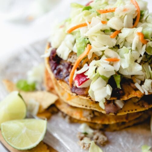 layered taco salad tostadas with slices of lime
