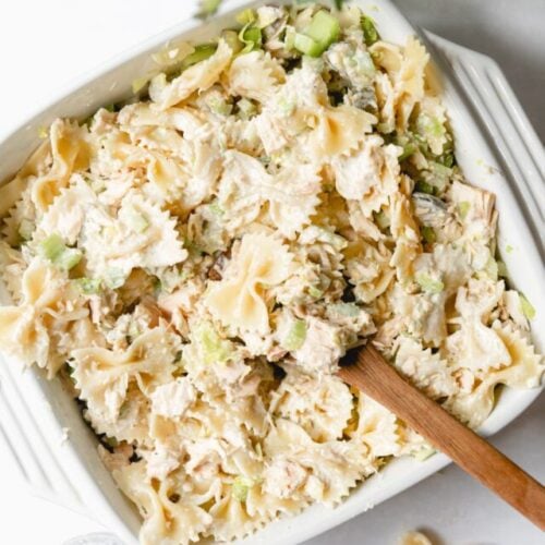 tuna pasta salad in a white square dish with a spoon in it