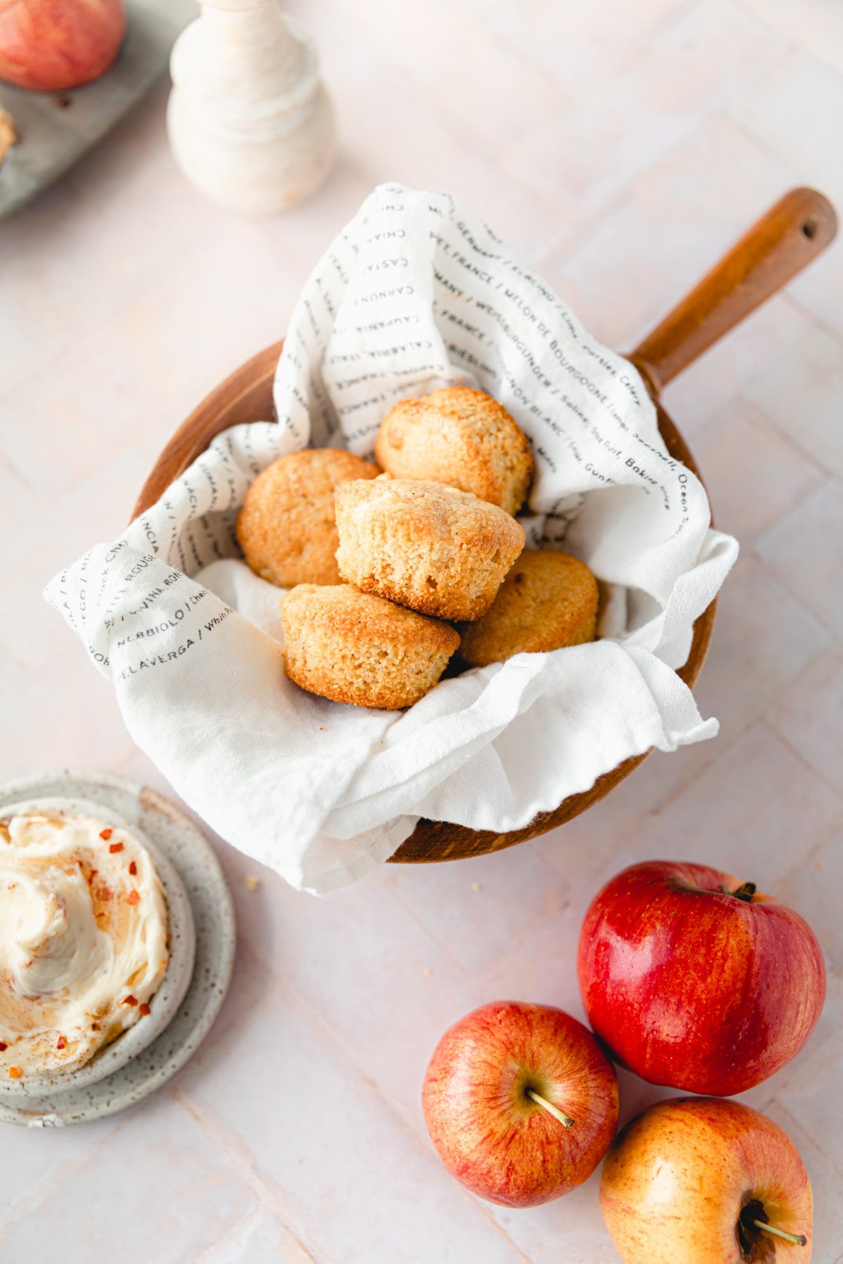 wooden bowl of cornbread muffins lined with a tea towel