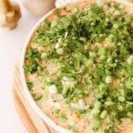 white bowl with shrimp dip topped with green onion