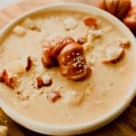 bowl of beer and cheese soup topped with soft pretzels