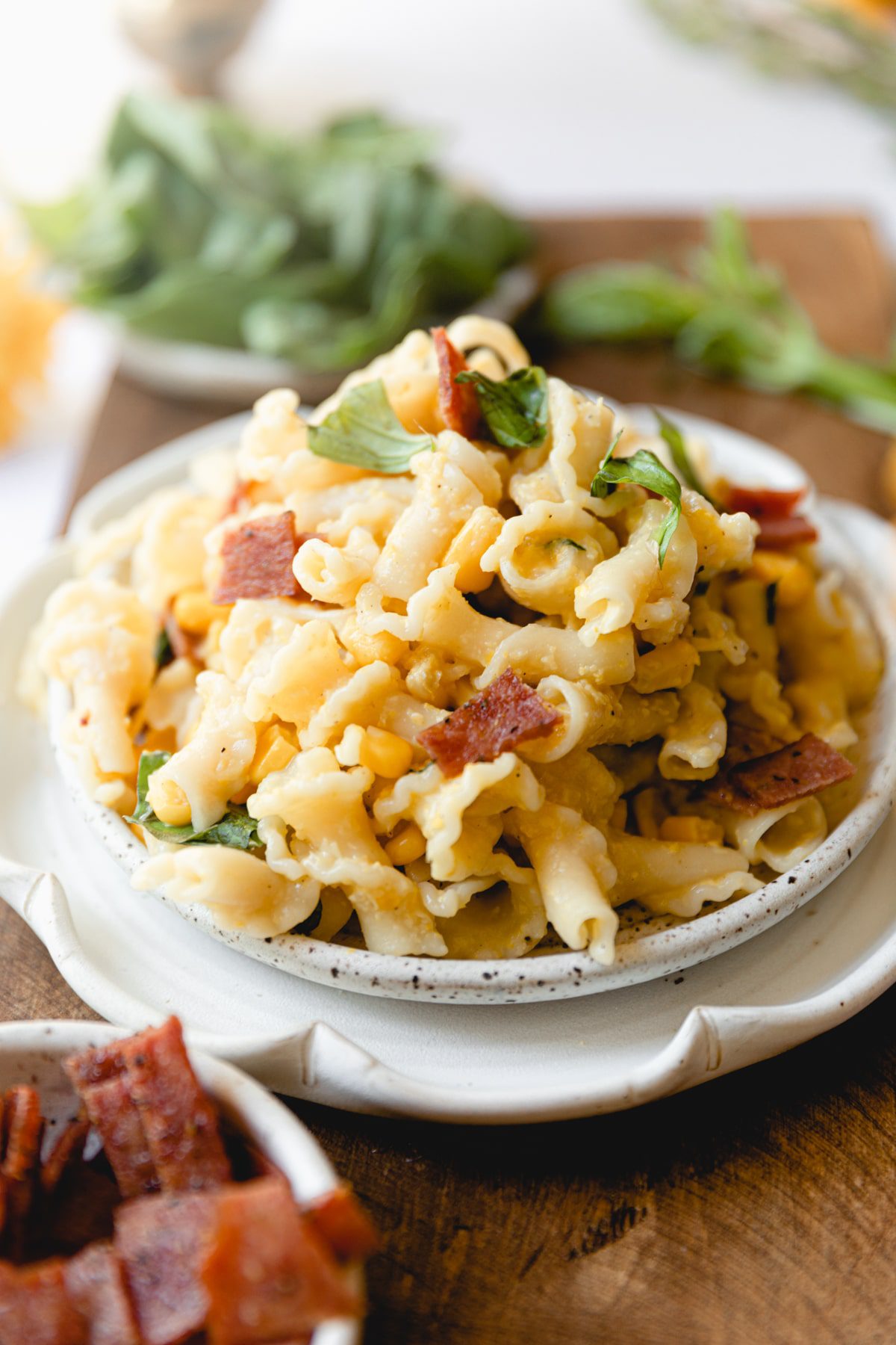 white plate piled high with chicken, bacon, sweet corn pasta