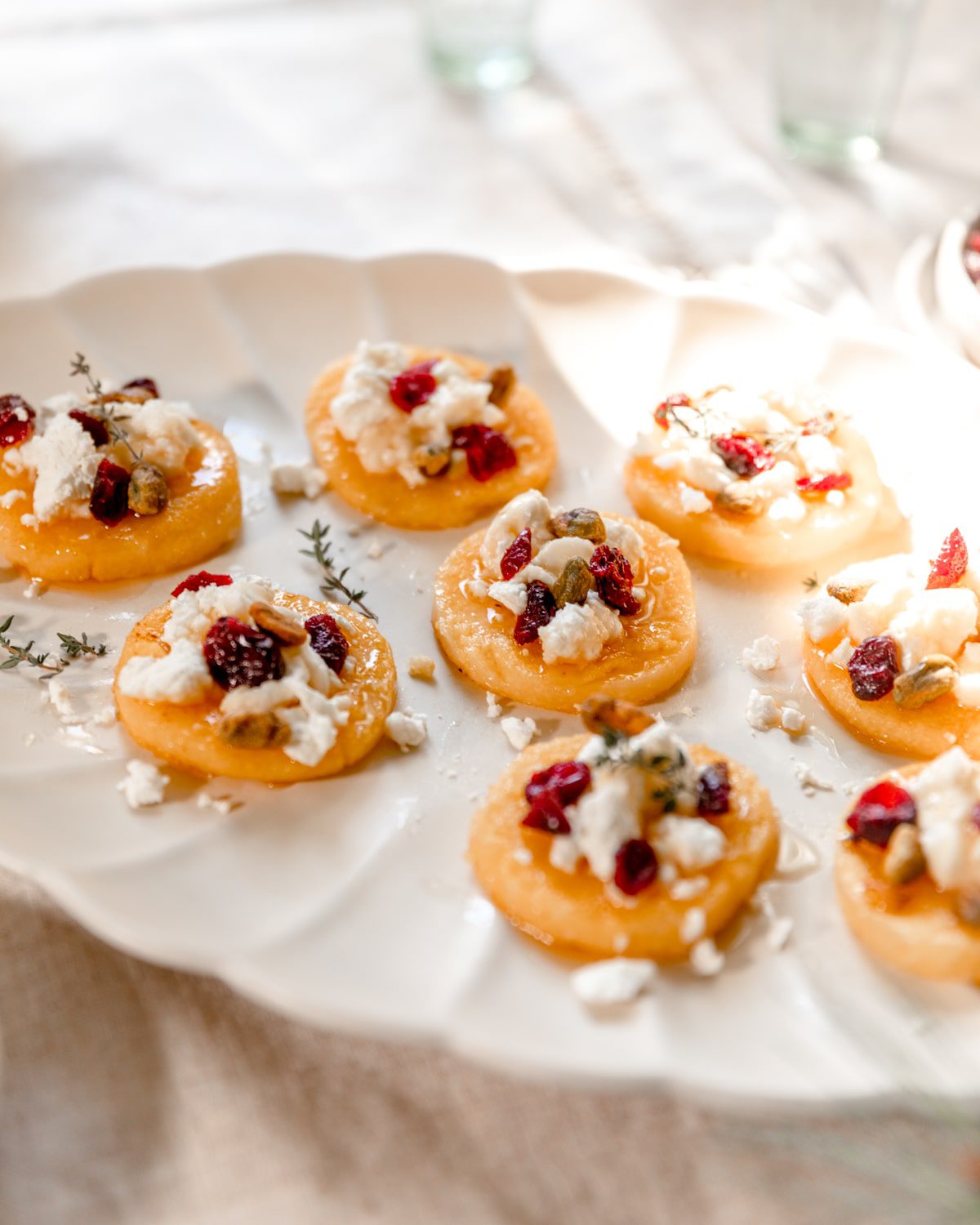 plate of polenta slices topped with goat cheese and honey