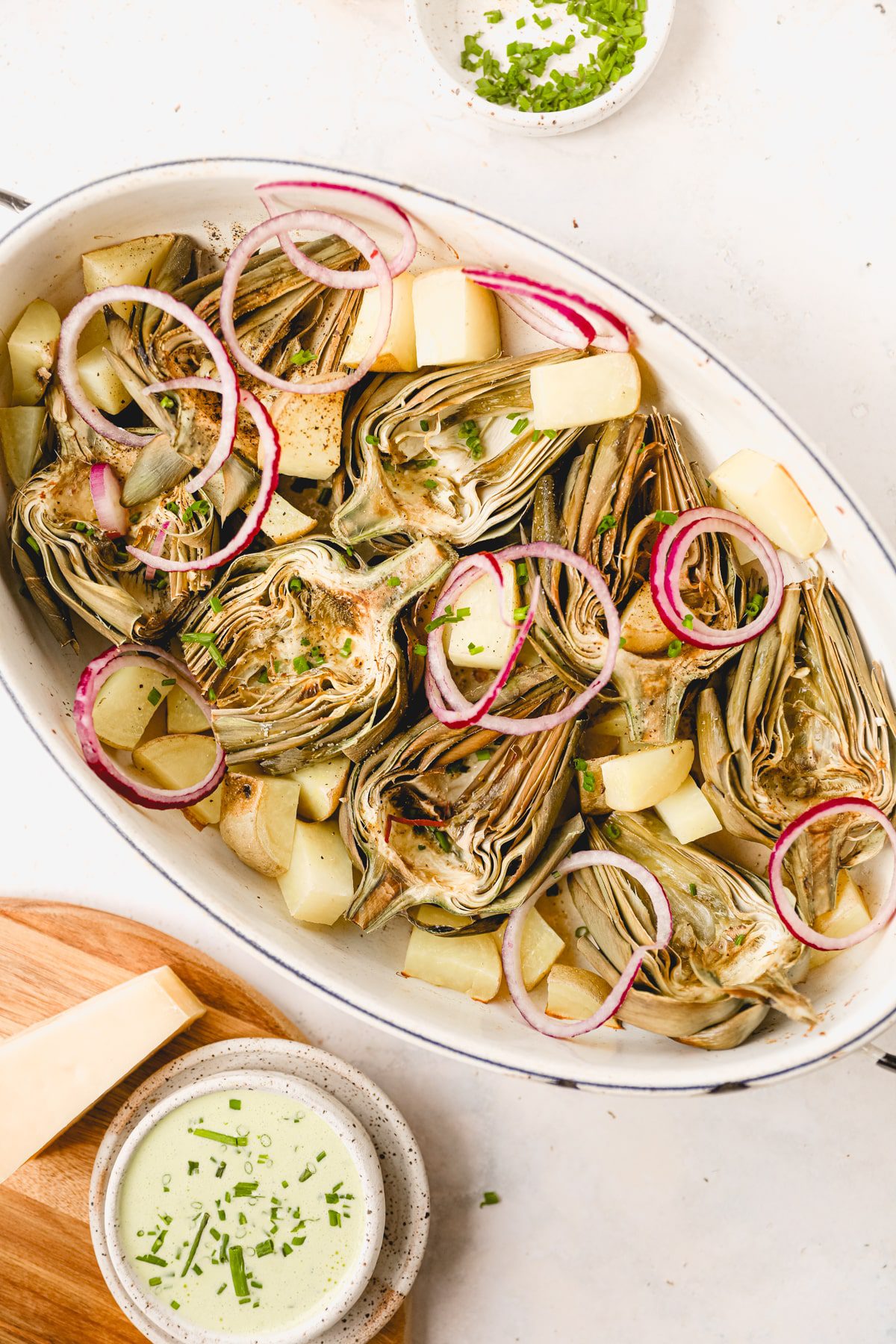 large roasting pan with roasted artichoke halves