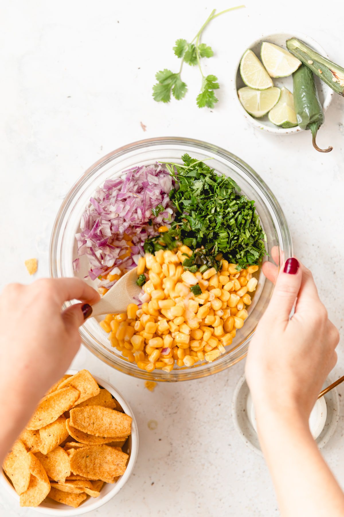 mixing corn and Chile salsa in a glass bowl