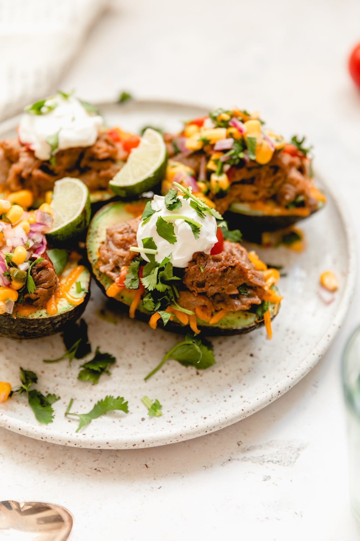 white plate with stuffed and baked avocados 