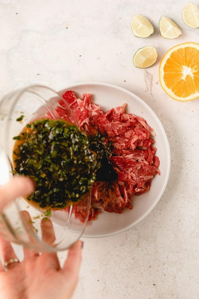 pouring marinade over shaved beef