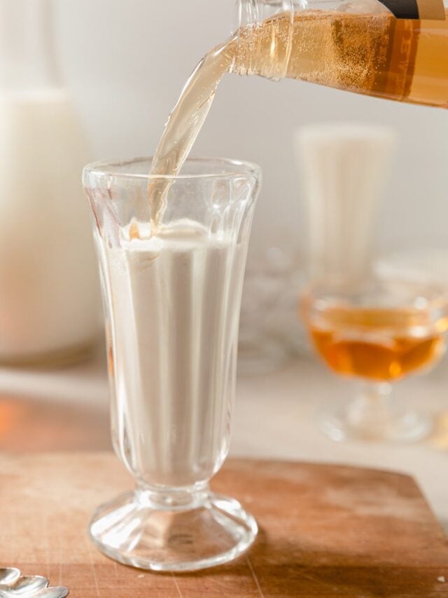 Pouring cream soda into bourbon cream in a glass