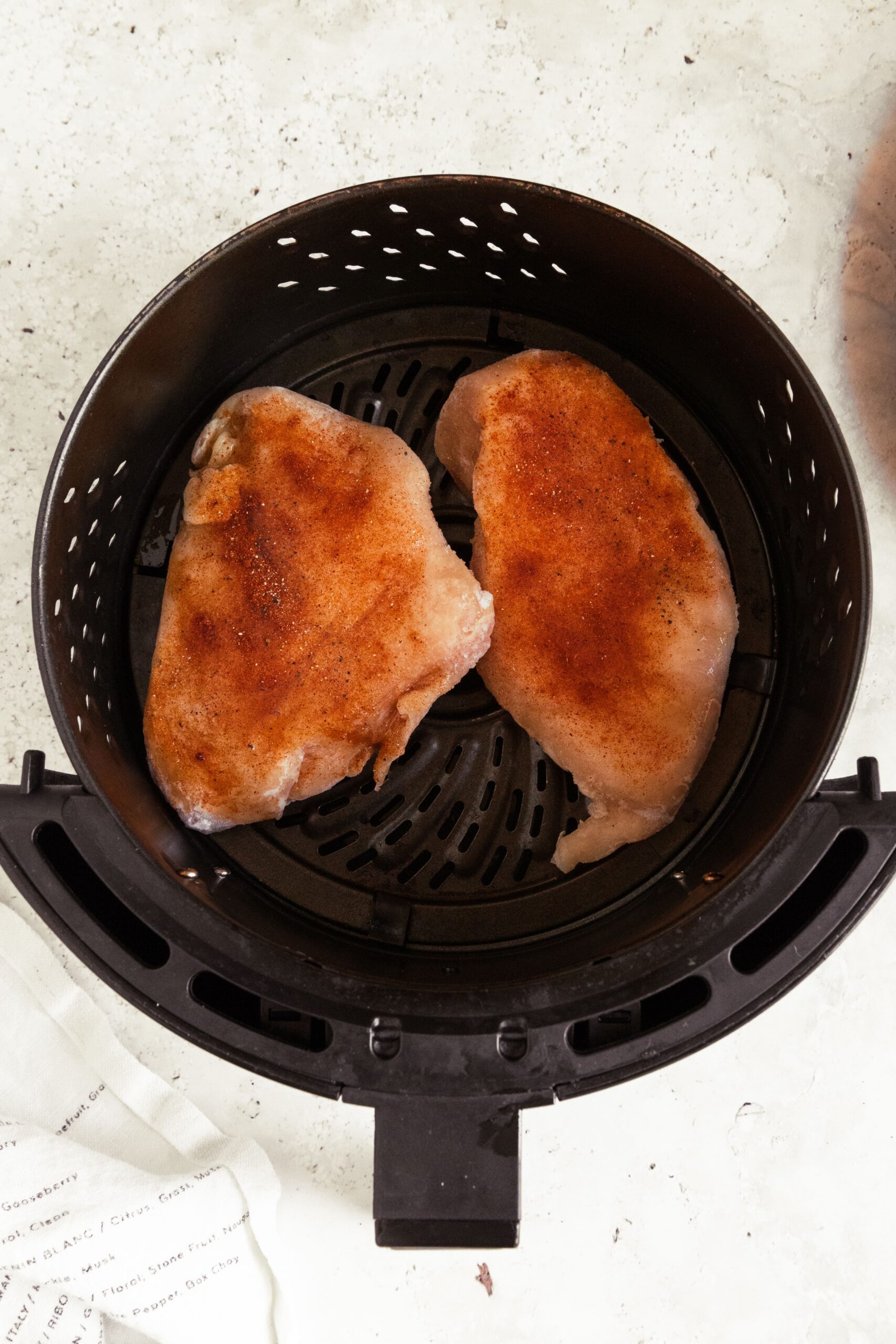 2 seasoned chicken breasts in an air fryer