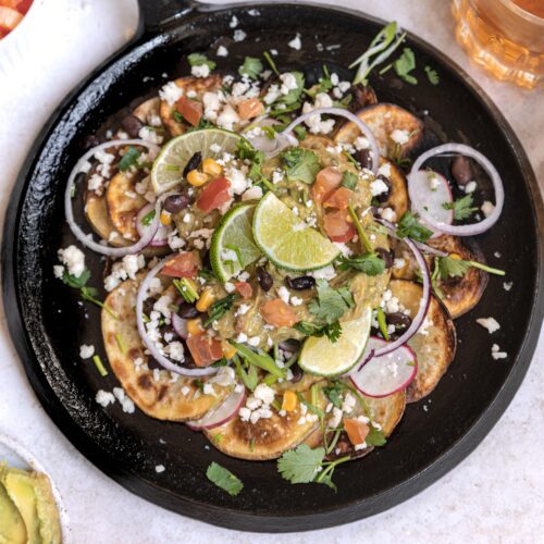 plate of Irish nachos with toppings on a cast iron skillet